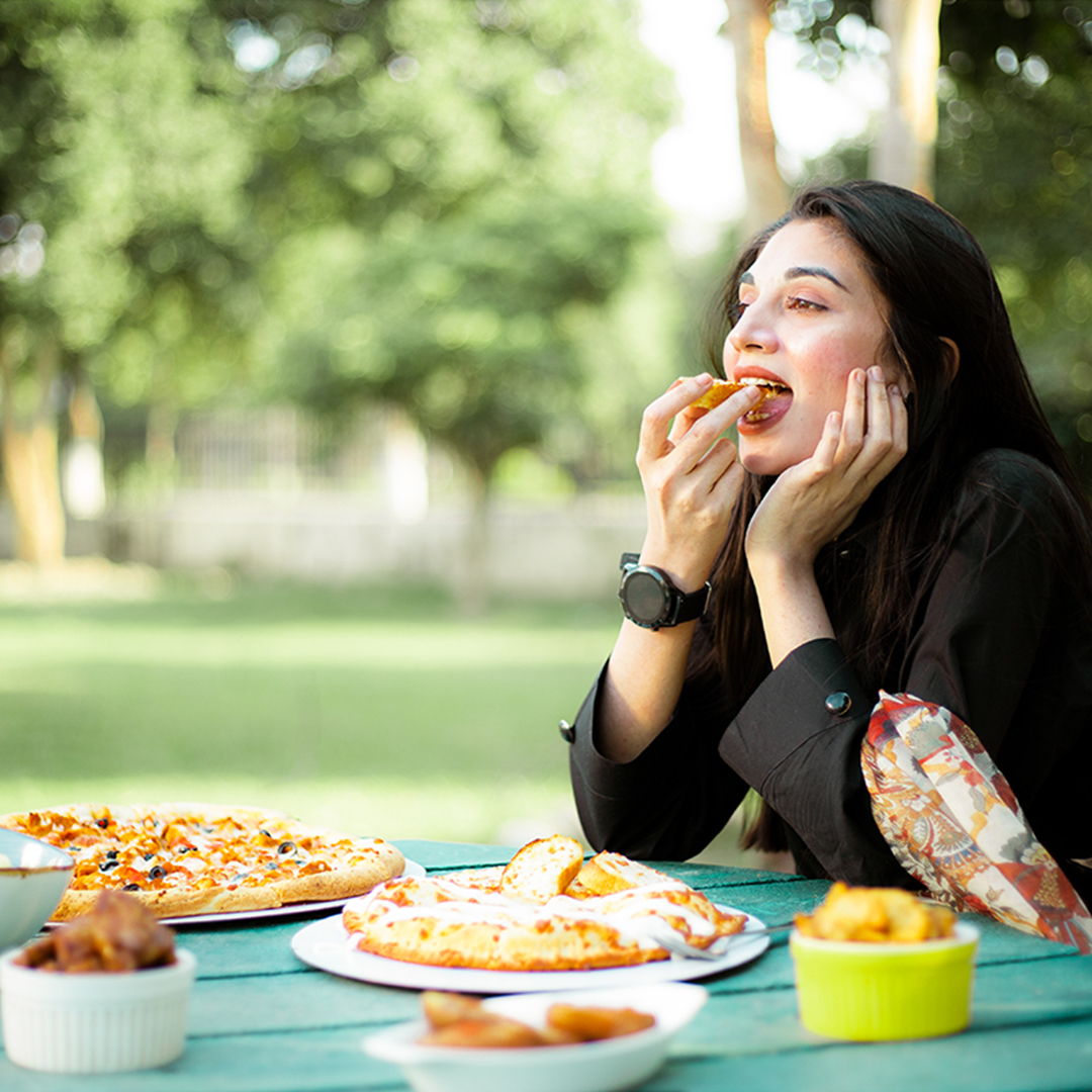 beautiful girl eating pizza and fast food outdoor